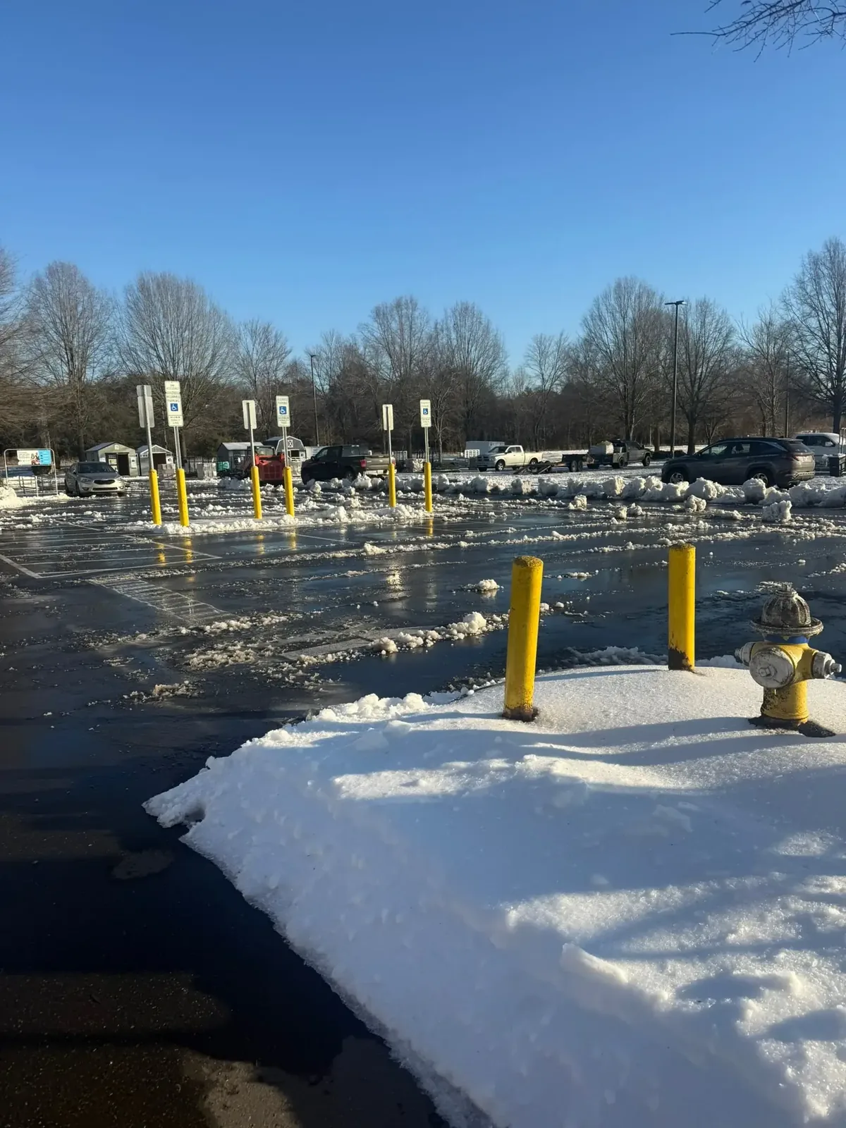 Home 21 Fonvilletreeservice winter parking lot scene with snow piles yellow bollards and fire hydrant after clearing in NC
